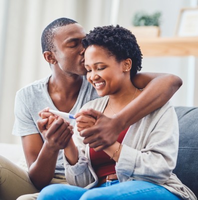 Couple reacts with joy to positive pregnancy test.